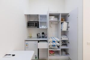 eine kleine Küche mit einem Kühlschrank und einer Mikrowelle in der Unterkunft Ташкентский Дворик in Taschkent