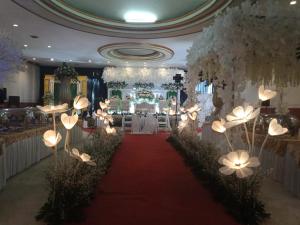 a banquet hall with a red carpet and white flowers at Hotel Syariah Taman Cibinong 2 By FPH 