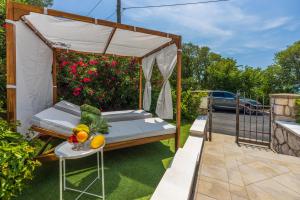 a gazebo with a bed and a table with fruit at Amarie in Dramalj