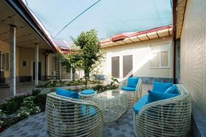 a patio with chairs and a table with blue pillows at Ташкентский Дворик in Tashkent