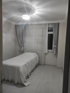 um quarto com uma cama branca e uma janela em BadalApart em Ardeşen