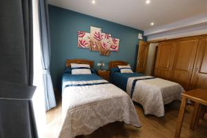 2 łóżka w pokoju z niebieskimi ścianami w obiekcie LUZ DE PRADA w mieście Puebla de Sanabria