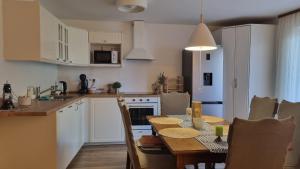 a kitchen and dining room with a table and chairs at Apartman Z12 in Kornić +9 photos
