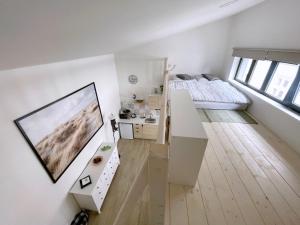 a white room with a bed and a tv on a wall at Comfortable apartments under the St. Barbara´s Cathedral in Kutná Hora