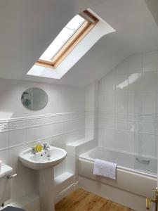 a bathroom with a sink and a bath tub and a skylight at Idillic Two bed country cottage in Kirkby Thore
