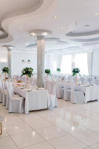 a banquet hall with white tables and white chairs at Malibu in Brzeźnica
