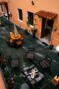 eine Terrasse mit einem Tisch und Stühlen im Innenhof in der Unterkunft La Posada Colonial in Quito