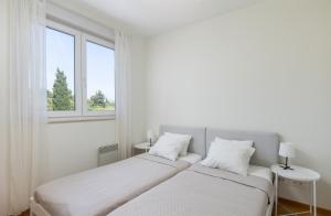 twee bedden in een witte kamer met twee ramen bij Flora Luxury Apartment in Dubrovnik