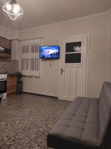 ein Wohnzimmer mit einem Sofa und einem Flachbild-TV in der Unterkunft Aurora nest in Gaios