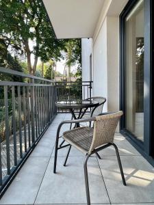 a patio with a table and chairs on a balcony at Willa Leśna in Ustka