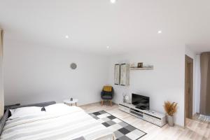 a white bedroom with a bed and a fireplace at Casa lui Matei Murighiol in Murighiol