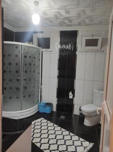 a bathroom with a toilet and black and white tiles at BadalApart in Ardeşen