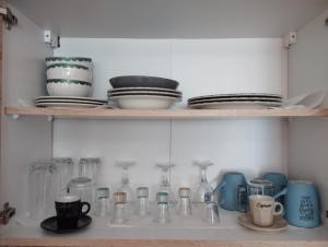 a shelf filled with glass jars and plates and dishes at Arcade City Apartment in Rethymno