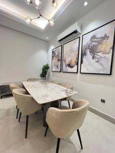 a dining room with a marble table and chairs at New apartment, two entrances in Riyadh