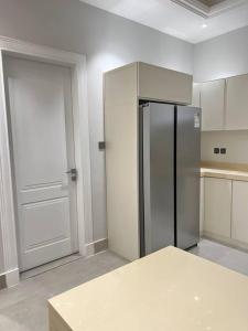 eine Küche mit einem Kühlschrank aus Edelstahl und einer Tür in der Unterkunft New apartment, two entrances in Riad
