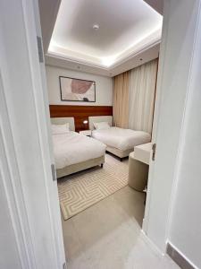 1 dormitorio pequeño con 2 camas y sofá en New apartment, two entrances, en Riad