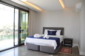 a bedroom with a bed with blue and white sheets at Villa Elite in Kusadası