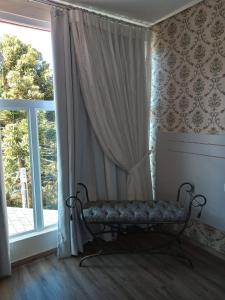 a room with a bench in front of a window at Pousada Serrano in Campos do Jordão