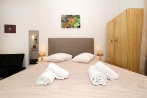 a bedroom with a large bed with white pillows at Feidiou 1, vol I in Egina