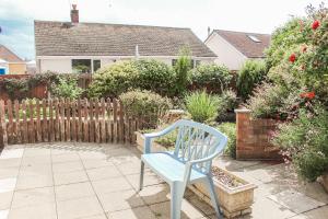 a blue chair sitting on a patio in front of a fence at Lovely Bungalow Close to Beach in Prestatyn