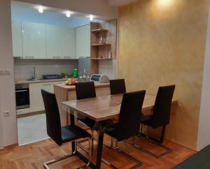奥赫里德APARTMENT GALAXY CENTAR OHRID的厨房配有木桌和黑色椅子
