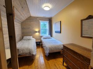 ein kleines Zimmer mit 2 Betten und einem Fenster in der Unterkunft 23Maple in Haliburton