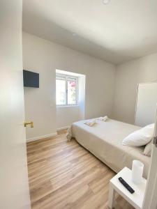 a white bedroom with a bed and a window at Casa da Nespereira in Portimão +17 photos
