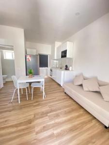 a white living room with a table and a couch at Casa da Nespereira in Portimão
