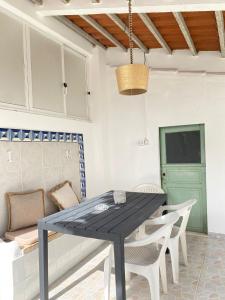 a dining room with a black table and white chairs at Casa da Nespereira in Portimão