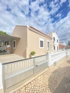 a house with a white fence on a street at Casa da Nespereira in Portimão