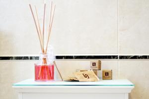 a vase with sticks in it sitting on a table at Hotel La Pigna in Marina di Pietrasanta