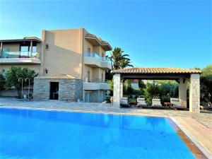 a swimming pool in front of a villa at Lili Hotel in Amoudara Herakliou