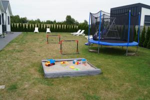- une aire de jeux avec trampoline et un jeu dans l'établissement SŁONECZNE DOMKI, à Gąski