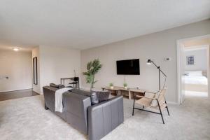 sala de estar con sofá, mesa y TV en Wonderful 2BR Condo @Crystal City With Gym en Arlington