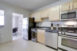 una cocina con electrodomésticos blancos y armarios de madera en Wonderful 2BR Condo @Crystal City With Gym en Arlington