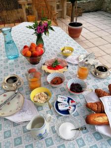 un tavolo con prodotti per la colazione e bevande di Le Verger du Paradis a Beaulieu-sur-Sonnette