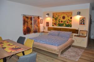 um quarto com uma cama, uma mesa e um quadro em Apartmán Nad potokem em Český Rudolec