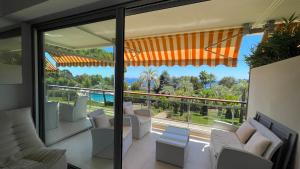 a living room with a view of the pool from a house at APPARTEMENT 2 chambres vue mer panoramique, proche Croisette Cannes in Vallauris