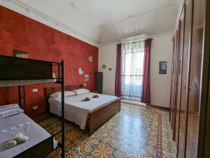 um quarto com 2 camas e paredes vermelhas em Il Cortile Siciliano Apartments em Trapani