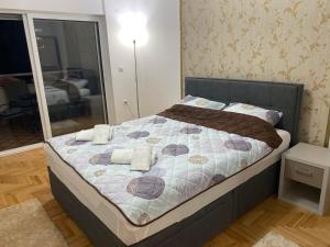 奥赫里德APARTMENT GALAXY CENTAR OHRID的一间卧室，床上有一张带毛巾的床 更多15张照片
