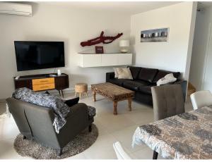 uma sala de estar com um sofá e uma televisão em Roquebrune Golfs Plages em Roquebrune-sur-Argens