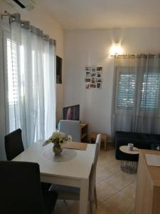 sala de estar con mesa, mesa blanca y sillas en Mala Basina -Maslina en Vrbanj