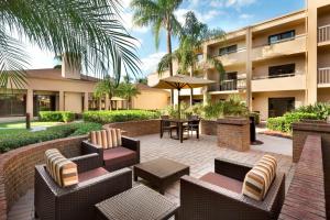 En el complejo hay un patio con mesas y sillas. en Courtyard Fort Myers Cape Coral, en Fort Myers