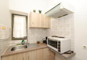 a small kitchen with a microwave and a sink at Feidiou 1, vol I in Egina