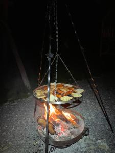 a hanging grill with food and a fire at Obrochtowa Chata in Kościelisko