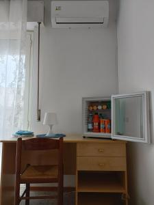 a desk with a cupboard and a table with a lamp at Domus Stadio in Pescara