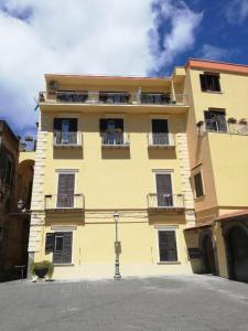 um edifício amarelo com janelas e varandas em Dimora Sorrento em Sant'Agnello