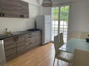 een keuken met een tafel en een witte koelkast bij Magnifique villa contemporaine 8 personnes in Pierrevert