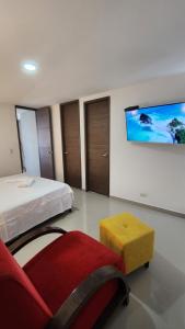 a bedroom with a bed and a couch and a tv at Apto zion in Medellín