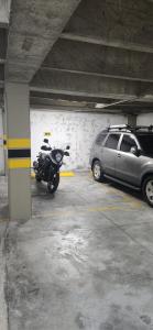 a parking garage with a motorcycle parked next to a car at Apto zion in Medellín